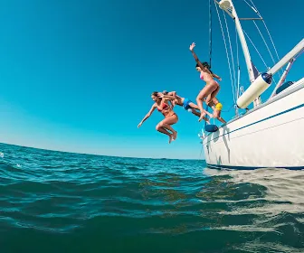 Plaisanciers sautant d'un voilier — bien commencer la saison nautique
