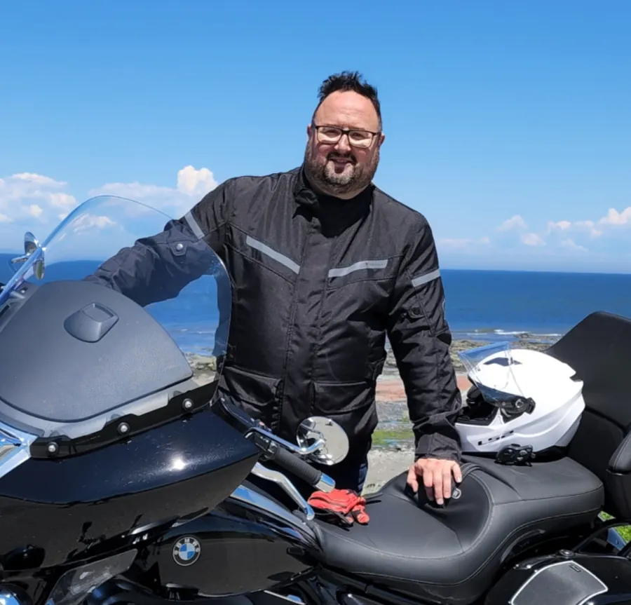 Patrice Rivest, chroniqueur en sports motorisés, avec la BMW R18 au bord du Saint-Laurent