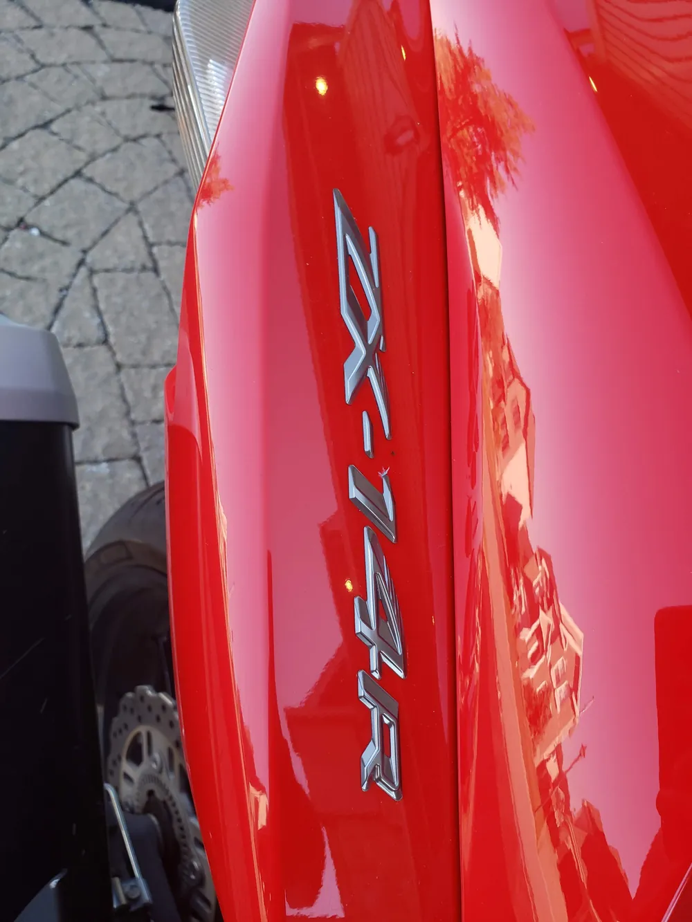 Gros plan sur l'écusson ZX-14R et la peinture Passion Red